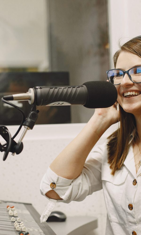 Female host communicating on Microphone. Woman in radio studio.
